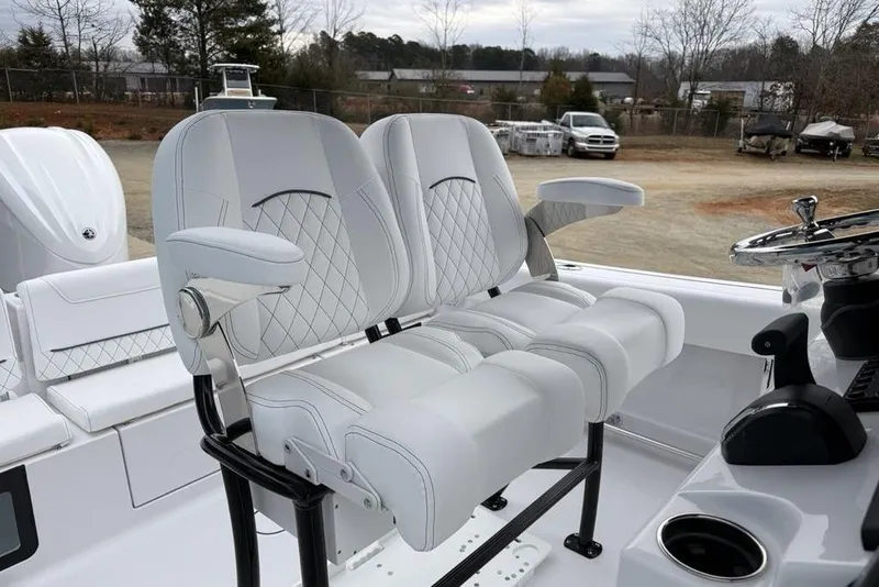 Slide: The Image of 2026 Sportsman Heritage 231 Center Console boat with luxurious white seating and steering wheel. - 15