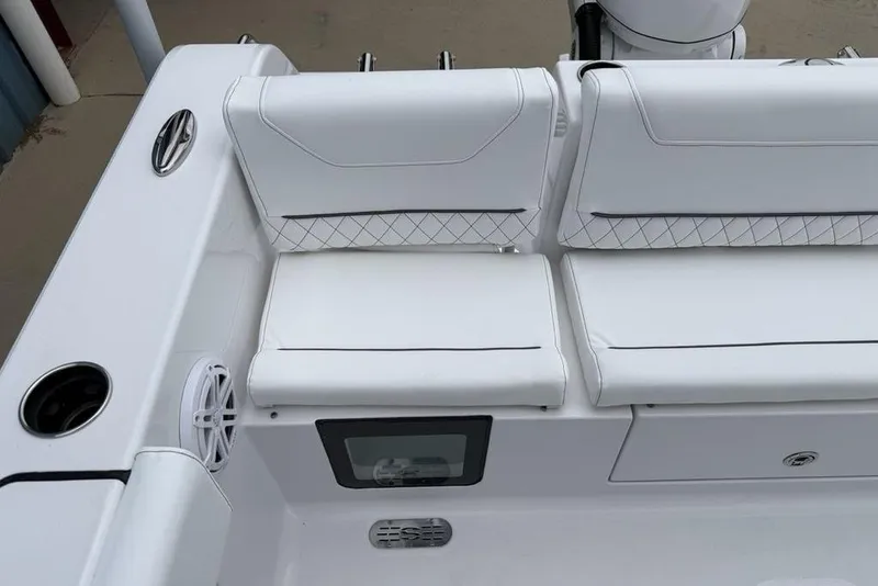 Slide: The Image of 2026 Sportsman Heritage 231 Center Console boat seating with white cushions and speaker. - 30