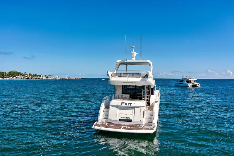 Slide: The Image of 2019 Sunseeker Manhattan 66 yacht on open sea, clear blue sky background. - 2