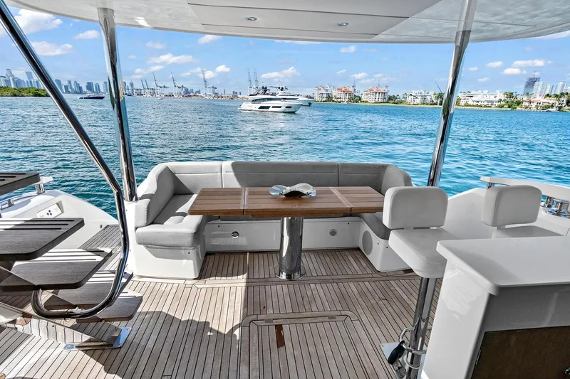 Slide: The Image of Luxurious Sunseeker Manhattan 66 yacht deck with seating, overlooking serene blue waters. - 5