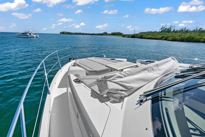Slide: The Image of 2019 Sunseeker Manhattan 66 yacht on serene blue waters under a clear sky. - 7