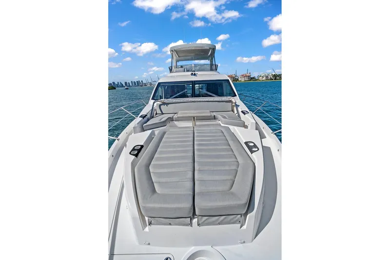 Slide: The Image of 2019 Sunseeker Manhattan 66 yacht with luxurious deck seating, cruising on a sunny day. - 8