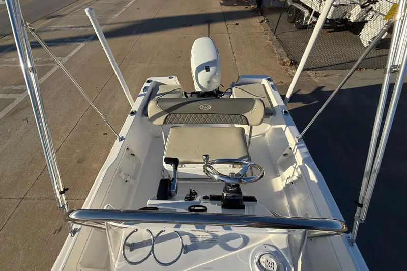 Slide: The Image of 2026 Key West 1720 Center Console boat with steering wheel and seating, docked on pavement. - 21