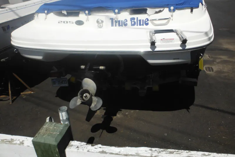Slide: The Image of 2011 Sea Ray 205 Sport boat named "True Blue" with blue cover, docked. - 16