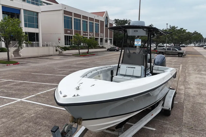 Slide: The Image of 1999 Contender 23 Open boat on trailer in parking lot near office building. - 10