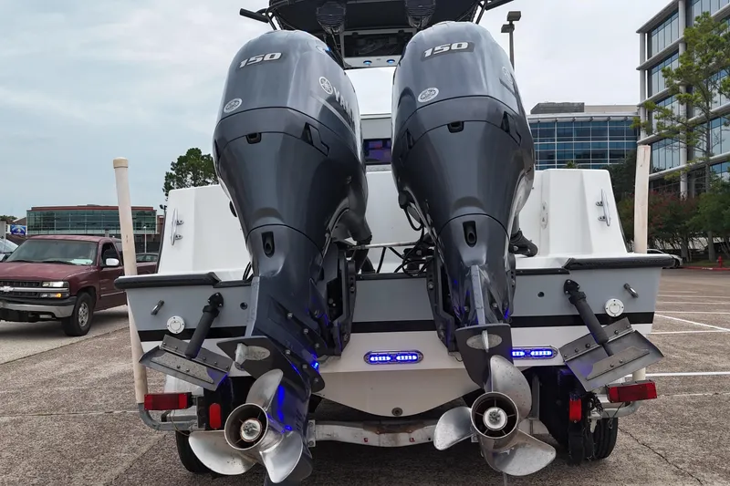 Slide: The Image of 1999 Contender 23 Open boat with dual Yamaha 150 outboard engines, parked in a lot. - 19