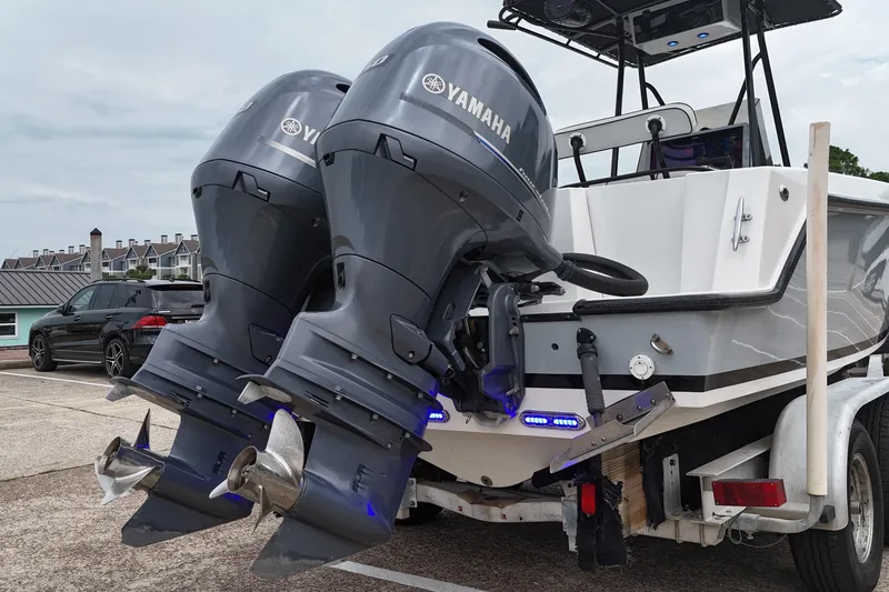 Slide: The Image of 1999 Contender 23 Open boat with dual Yamaha outboard motors on a trailer. - 20