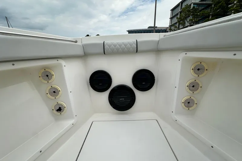 Slide: The Image of 1999 Contender 23 Open boat interior with speakers and seating, under cloudy sky. - 24