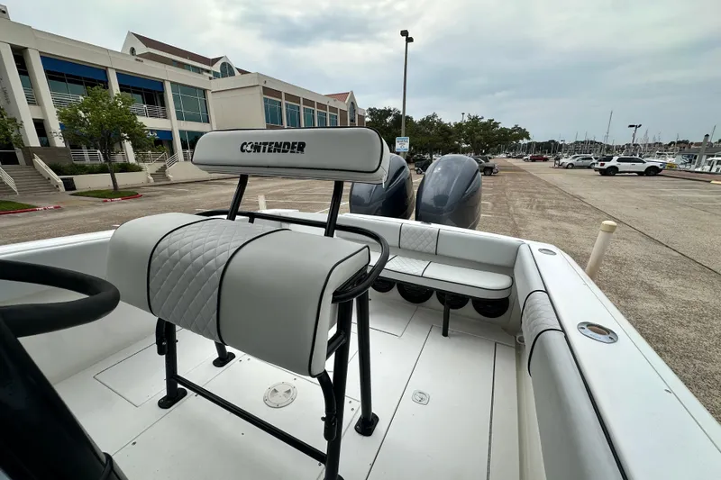 Slide: The Image of 1999 Contender 23 Open boat with dual engines, docked near a marina. - 28