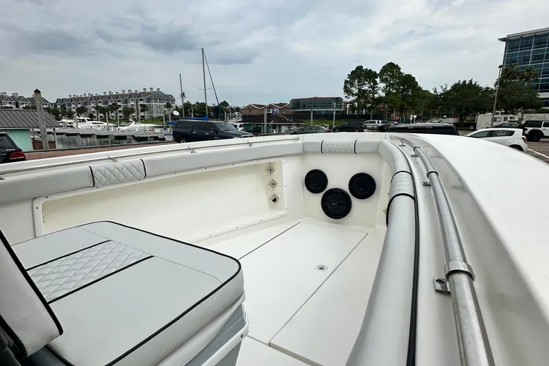 Slide: The Image of 1999 Contender 23 Open boat interior with seating and speakers at a marina. - 30