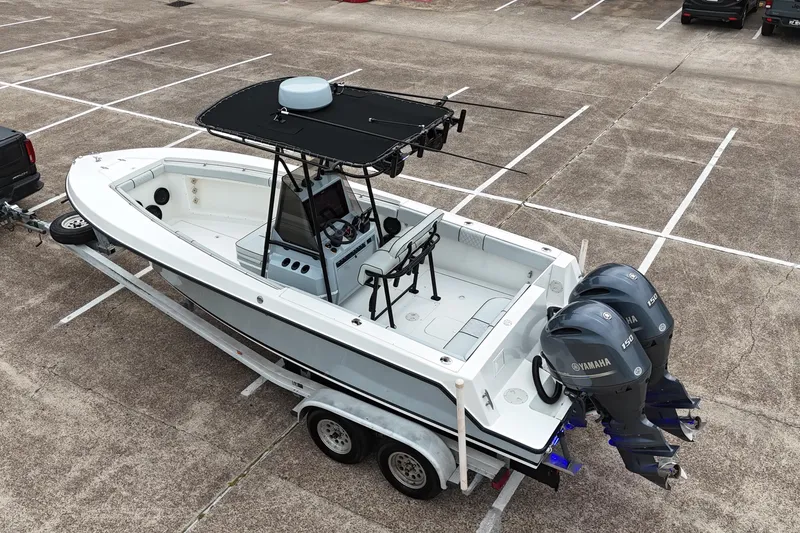 Slide: The Image of 1999 Contender 23 Open boat on trailer with twin Yamaha engines in parking lot. - 4