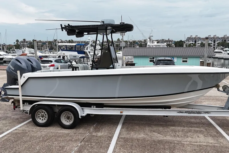 Slide: The Image of 1999 Contender 23 Open boat on trailer at marina, with Yamaha engines. - 7