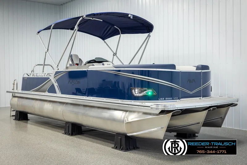 Slide: The Image of 2026 Avalon LSZ VRB pontoon boat with blue canopy in showroom display. - 3