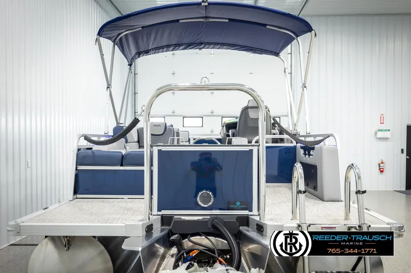 Slide: The Image of 2026 Avalon LSZ VRB pontoon boat in showroom, featuring blue canopy and seating. - 7