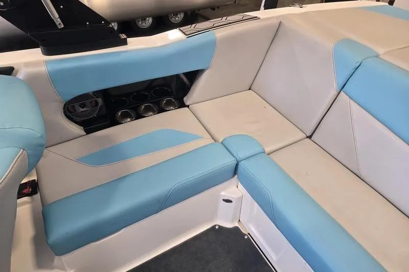 Slide: The Image of 2020 MasterCraft NXT20 boat interior with blue and gray seating and cup holders. - 11