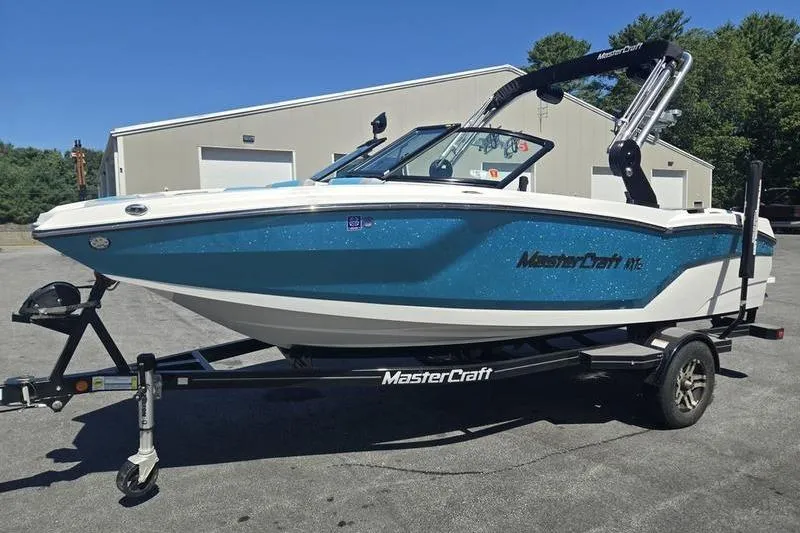 Slide: The Image of 2020 MasterCraft NXT20 boat on trailer, parked outdoors near a building. - 13
