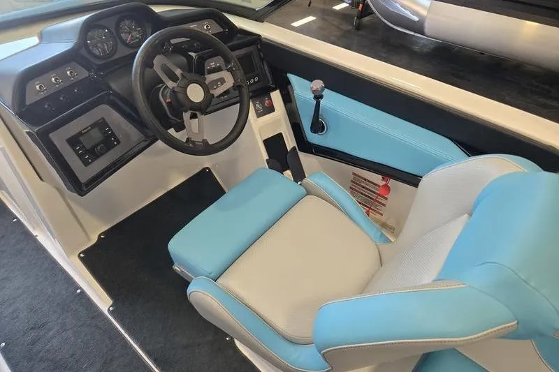 Slide: The Image of 2020 MasterCraft NXT20 boat interior with blue and white seating, steering wheel, and dashboard controls. - 21