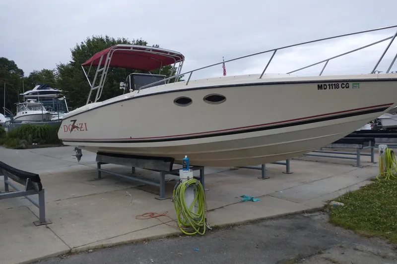 Slide: The Image of 1990 Donzi F-33 boat on trailer, red canopy, parked outdoors. - 0