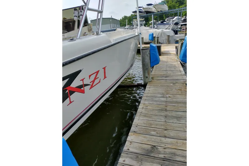 Slide: The Image of 1990 Donzi F-33 boat docked at a marina with wooden pier. - 2