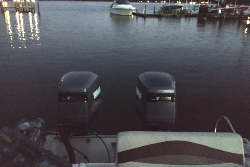 Slide: The Image of Twin Yamaha V225 outboard motors on a 1990 Donzi F-33 boat at a marina. - 8
