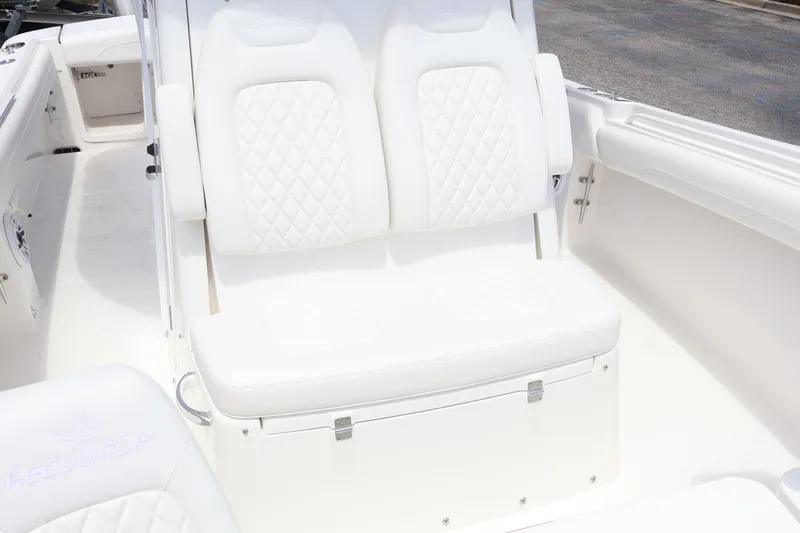 Slide: The Image of 2026 Regulator 25 boat interior with white cushioned seating and diamond stitching. - 16