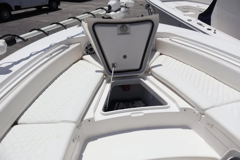 Slide: The Image of 2026 Regulator 25 boat with open storage compartment and cushioned seating. - 18