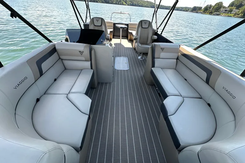 Slide: The Image of Luxurious 2023 Viaggio 22U pontoon boat interior with plush seating on a serene lake. - 13