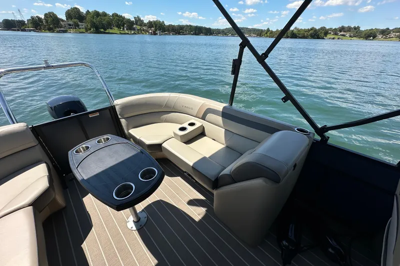 Slide: The Image of 2023 Viaggio 22U pontoon boat interior with seating and table on a lake. - 14