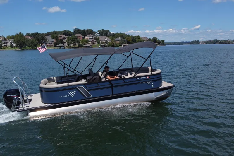 Slide: The Image of 2023 Viaggio 22U pontoon boat cruising on a lake under a clear blue sky. - 2