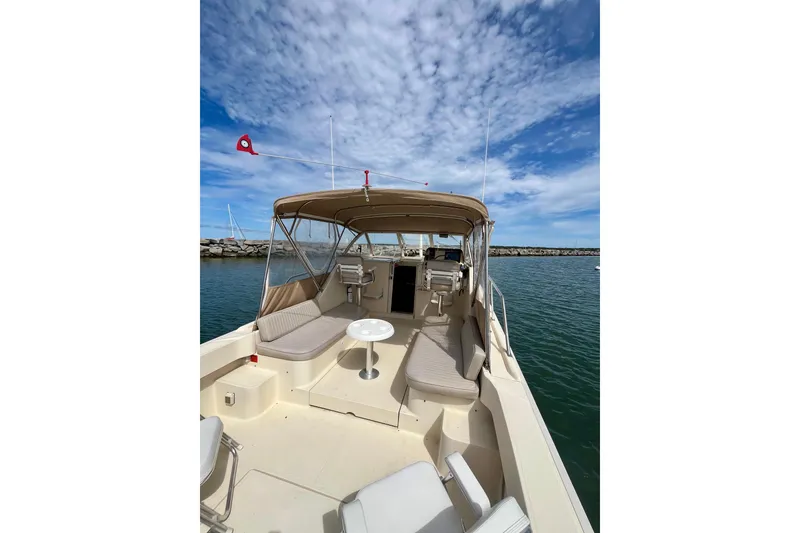 Slide: The Image of 2005 Mainship Pilot 30-II boat with spacious deck and seating under a clear sky. - 13