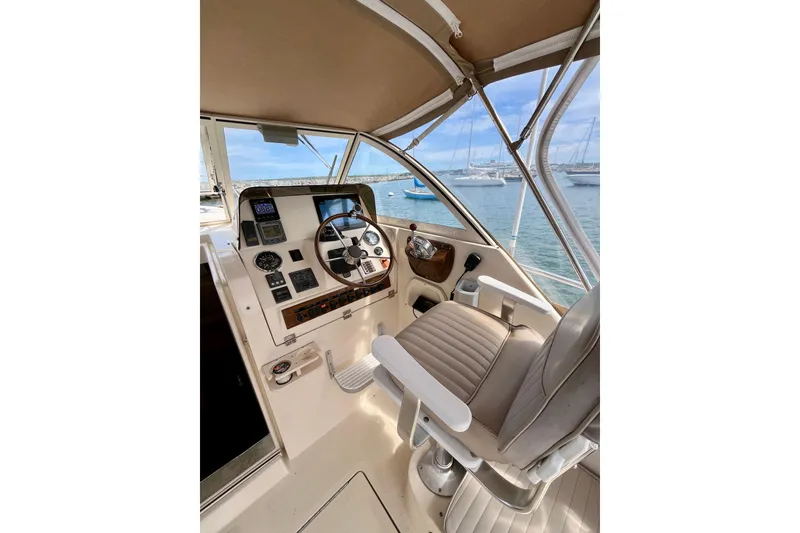 Slide: The Image of 2005 Mainship Pilot 30-II helm with steering wheel, controls, and ocean view. - 19