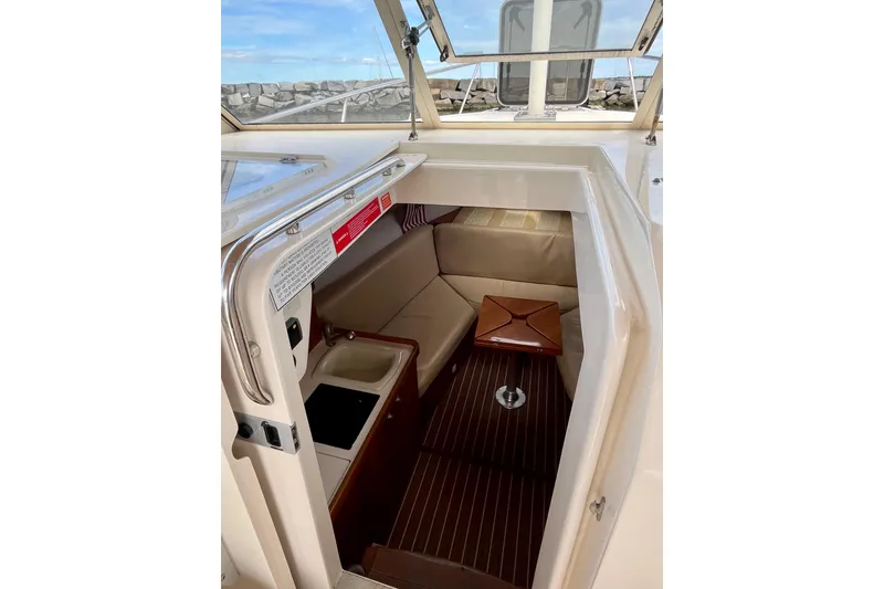 Slide: The Image of 2005 Mainship Pilot 30-II cabin interior with seating and compact kitchenette. - 33