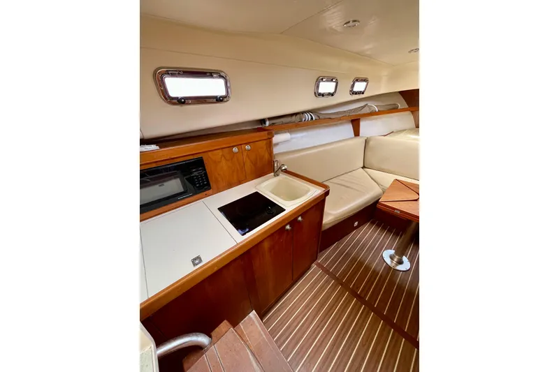 Slide: The Image of 2005 Mainship Pilot 30-II cabin interior with kitchenette and seating area. - 35
