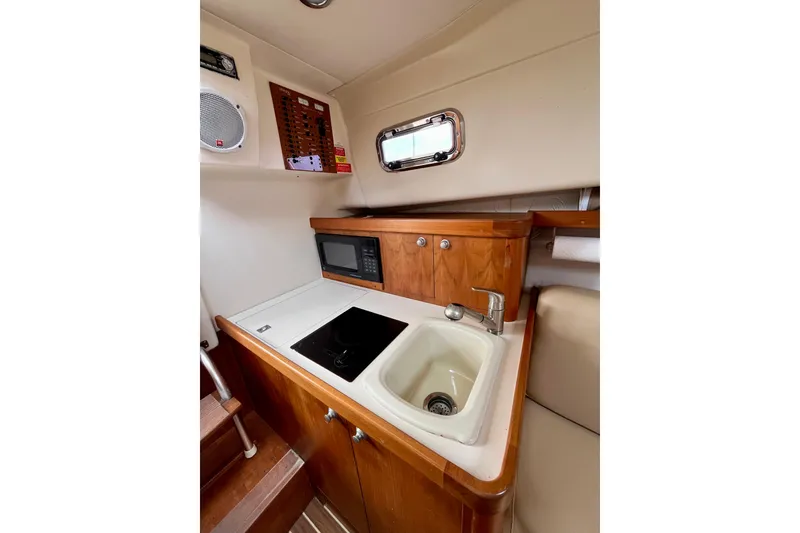 Slide: The Image of 2005 Mainship Pilot 30-II galley with sink, stove, and microwave. - 36