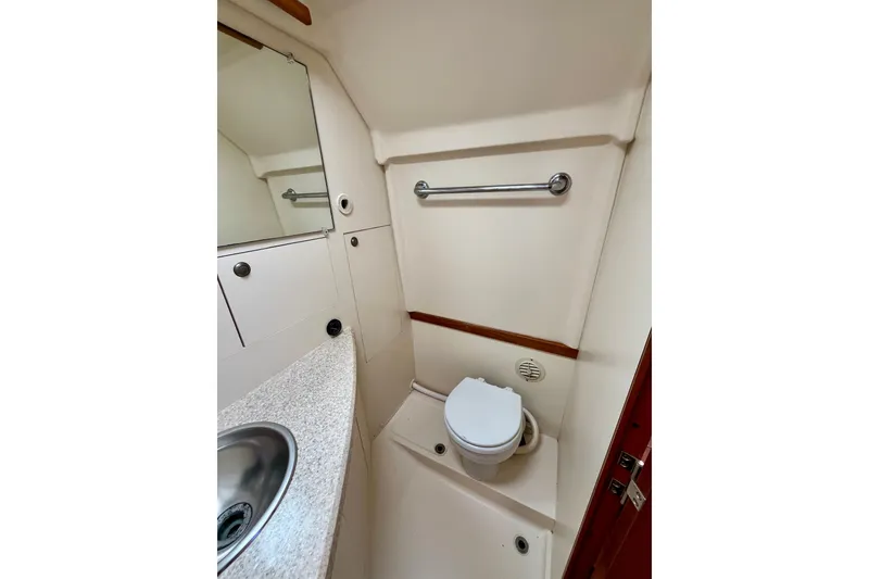 Slide: The Image of 2005 Mainship Pilot 30-II boat bathroom with sink, mirror, and toilet. - 41