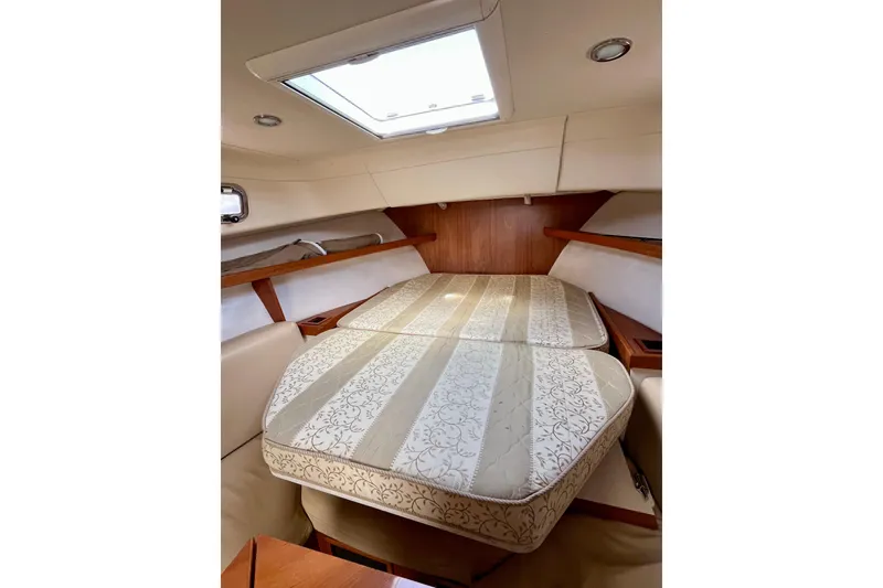 Slide: The Image of 2005 Mainship Pilot 30-II cabin interior with bed, skylight, and wooden accents. - 47