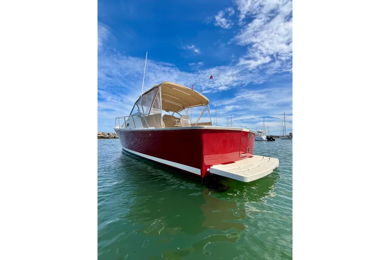 Slide: The Image of 2005 Mainship Pilot 30-II boat with red hull, docked under blue sky. - 51