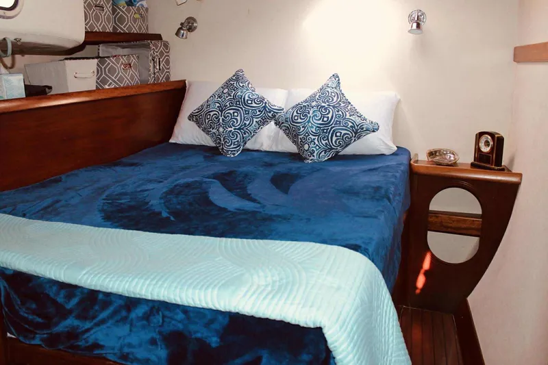Slide: The Image of Cozy cabin interior of 2000 Fountaine Pajot Belize 43 with blue bedding and decorative pillows. - 6