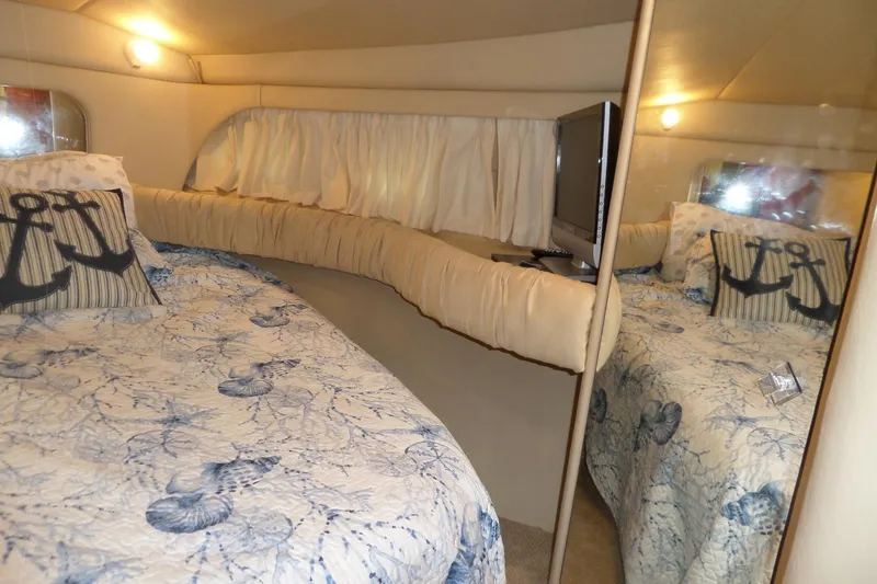 Slide: The Image of Cozy cabin interior of 2000 Sea Ray 380 Aft, featuring nautical-themed bedding. - 100
