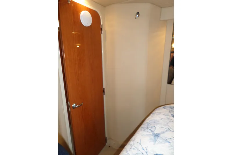 Slide: The Image of Interior of 2000 Sea Ray 380 Aft Cabin with wooden door and cozy bedding. - 104