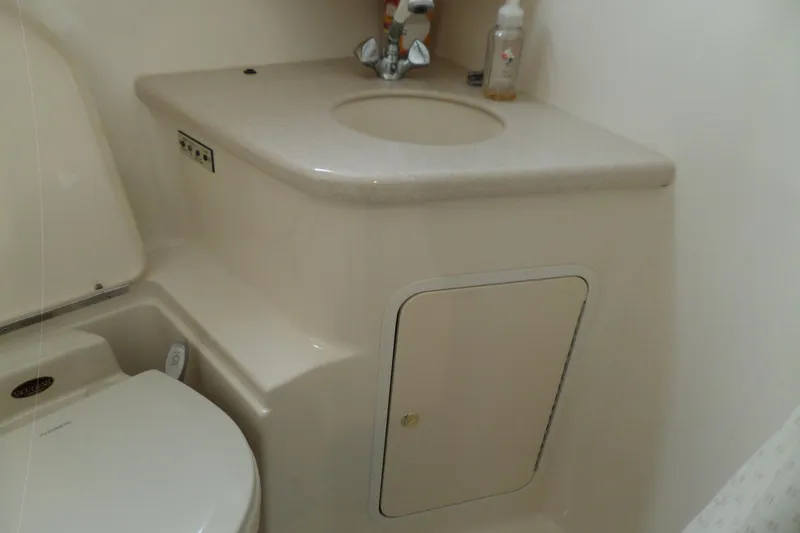 Slide: The Image of 2000 Sea Ray 380 Aft Cabin bathroom with sink and toilet, compact marine design. - 109