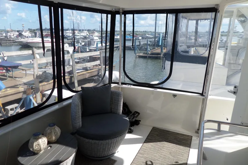 Slide: The Image of 2000 Sea Ray 380 Aft Cabin interior with marina view, featuring cozy seating and decor. - 36