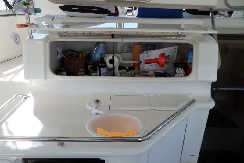 Slide: The Image of 2000 Sea Ray 380 Aft Cabin boat interior storage with sink and various items. - 44