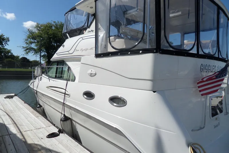 Slide: The Image of 2000 Sea Ray 380 Aft Cabin yacht docked, featuring sleek design and American flag. - 5