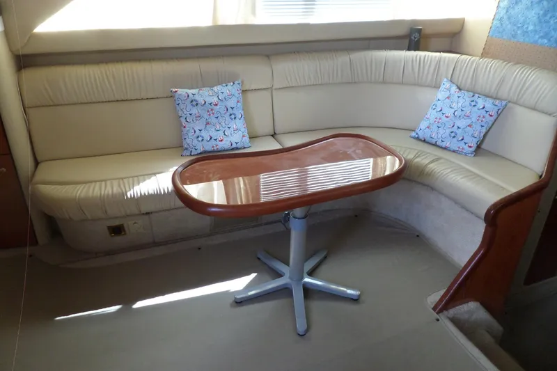 Slide: The Image of Interior of 2000 Sea Ray 380 Aft Cabin with curved seating and wooden table. - 55