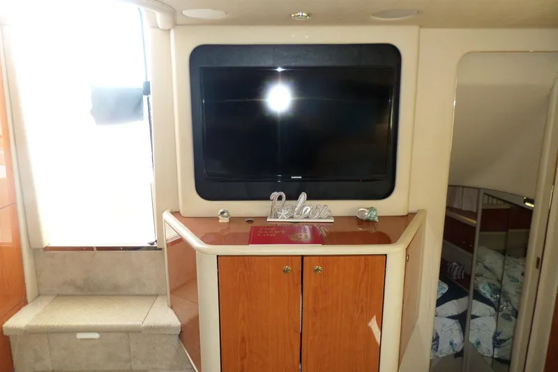 Slide: The Image of Interior of 2000 Sea Ray 380 Aft Cabin with TV and wooden cabinets. - 56