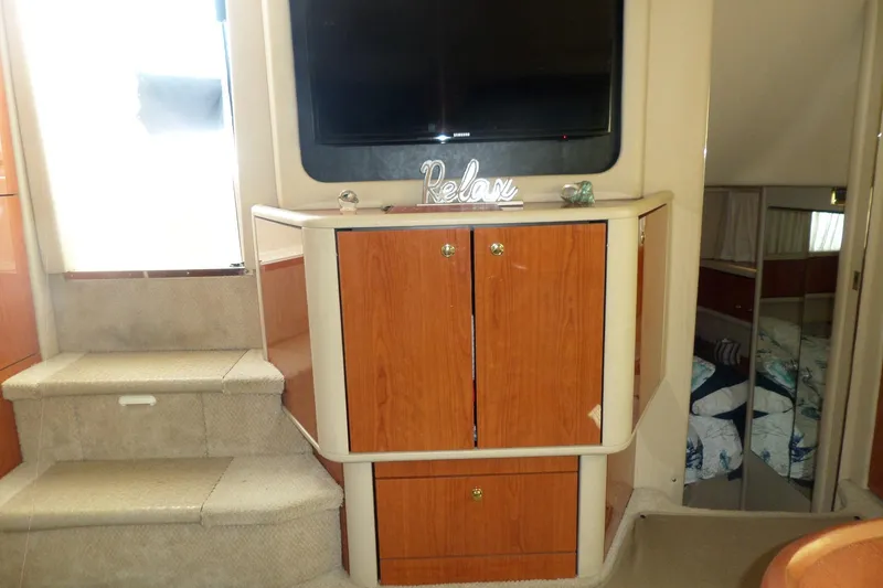 Slide: The Image of Interior of 2000 Sea Ray 380 Aft Cabin with wooden cabinets and "Relax" decor. - 57