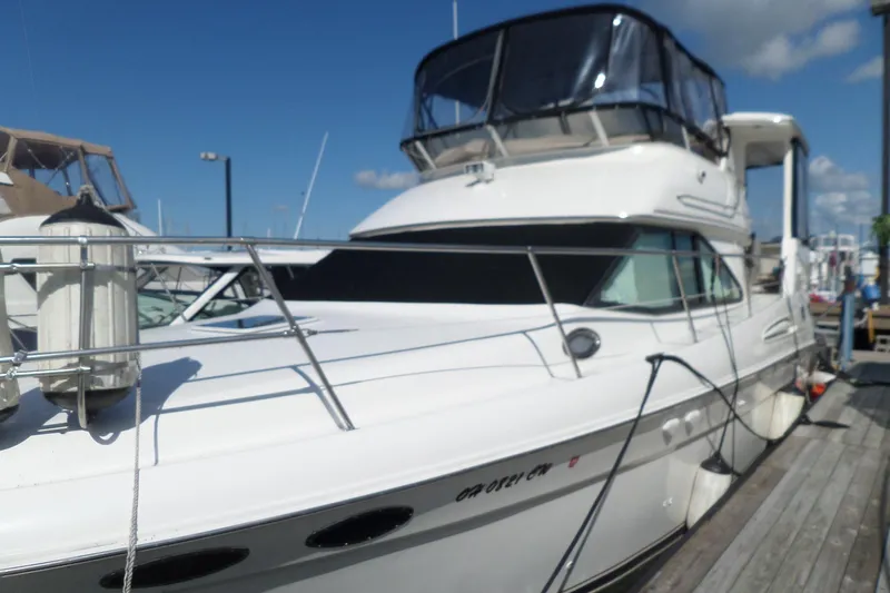 Slide: The Image of 2000 Sea Ray 380 Aft Cabin yacht docked at marina under clear blue sky. - 6