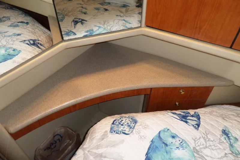 Slide: The Image of Interior of 2000 Sea Ray 380 Aft Cabin with corner shelf and fish-patterned bedding. - 67