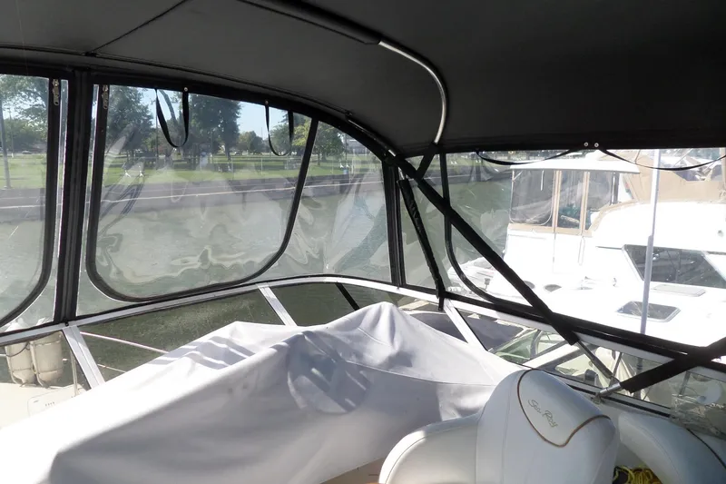 Slide: The Image of 2000 Sea Ray 380 Aft Cabin interior with covered seating and marina view. - 8